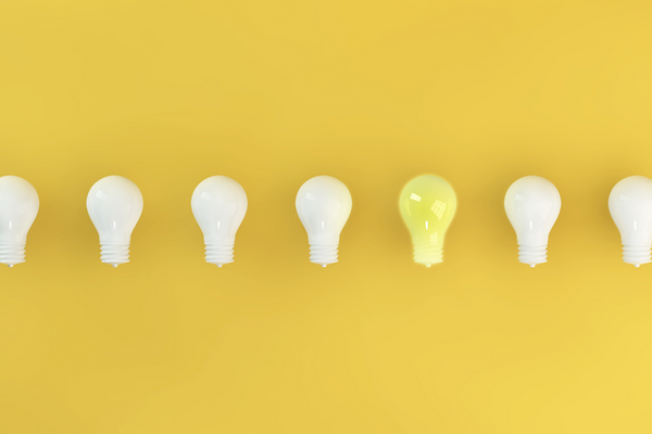 a collection of lightbulbs, one is yellow while the others are white